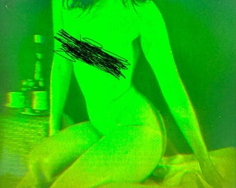 Può includere: Una donna è seduta su un letto, indossando una camicia verde. L'immagine è in uno schema di colori verde.