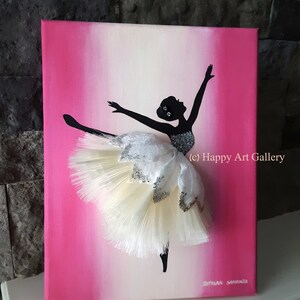 May include: A pink and white ombre canvas painting of a ballerina silhouette with a white and silver tutu. The tutu is made of fabric and has a 3D effect. The painting is signed "Diyasri Samantha" and includes the text "(c) Happy Art Gallery".