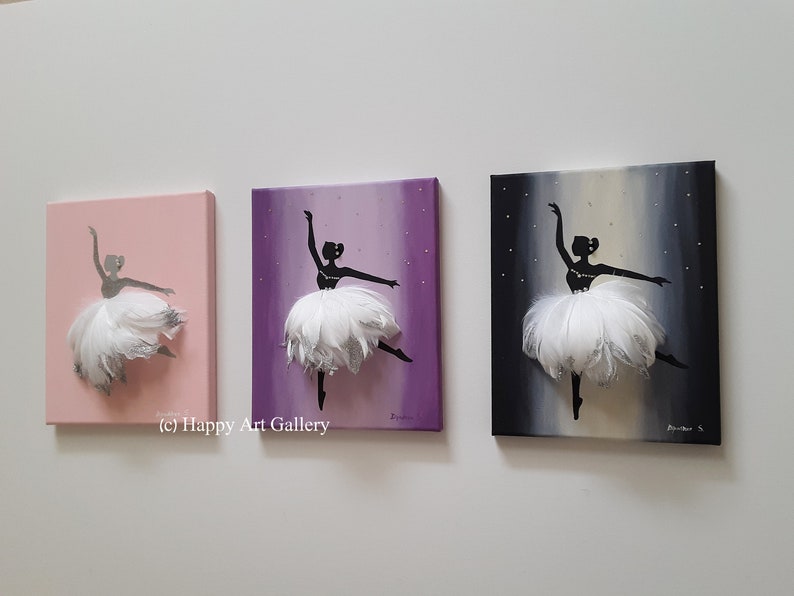 May include: Three canvas paintings of a ballerina silhouette with a white feather tutu. The ballerina is painted on a pink, purple, and black background with silver glitter accents.