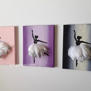 May include: Three canvas paintings of a ballerina silhouette with a white feather tutu. The ballerina is painted in black with silver glitter accents. The backgrounds are pink, purple, and gray with silver glitter stars.