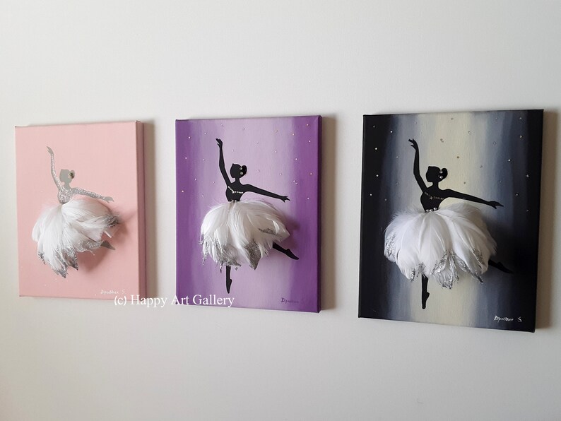 May include: Three canvas paintings of a ballerina silhouette with a white feather tutu. The ballerina is painted in black with silver glitter accents. The backgrounds are pink, purple, and gray with silver glitter stars.