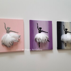 May include: Three canvas paintings of a ballerina silhouette with a white feather tutu. The ballerina is painted on a pink, purple, and black background.