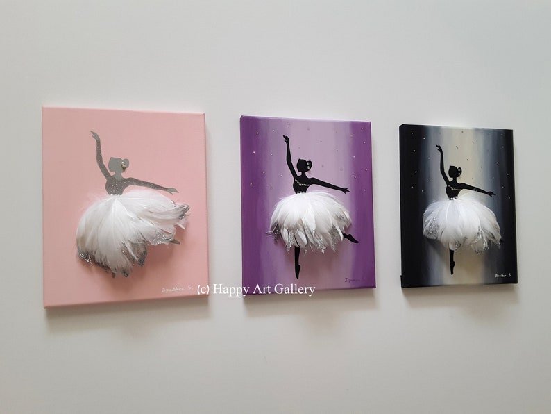 May include: Three canvas paintings of a ballerina silhouette with a white feather tutu. The ballerina is painted on a pink, purple, and black background.