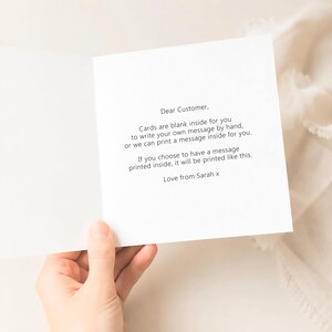 Op de afbeelding: Een witte wenskaart met zwarte tekst die luidt: Dear Customer, Cards are blank inside for you to write your own message by hand, or we can print a message inside for you. If you choose to have a message printed inside, it will be printed like this. Love from Sarah x.