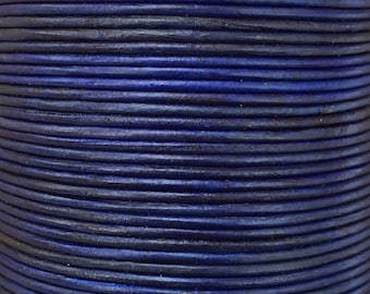 May include: Close-up of a spool of dark blue leather cord. The cord is tightly wound and has a smooth, polished finish.