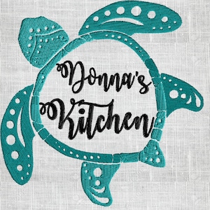 Puede incluir: Diseño de tortuga bordada en azul turquesa con el texto "Donna's Kitchen" dentro del círculo formado por el caparazón de la tortuga.
