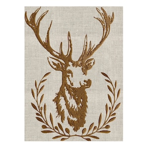 Può includere: Una testa di cervo ricamata di colore marrone con corna, circondata da una ghirlanda di foglie su uno sfondo di lino beige.