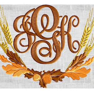 Op de afbeelding: Geborduurde monogram met de letters "K" en "F" in een bruin schrijflettertype. Het monogram is omringd door een krans van tarwehalmen en eikenbladeren in tinten bruin, oranje en geel.