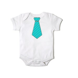 May include: White baby onesie with a turquoise tie design printed on the front.