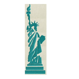 May include: Teal embroidered depiction of the Statue of Liberty on a beige rectangular background. The statue is rendered in a geometric, stylized design, holding a torch and a tablet. The embroidery has a textured appearance.