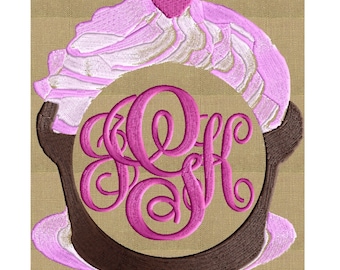 May include: Embroidered design of a baby's head with a pink heart on top and a pink monogram in a circle. The design is on a brown fabric background.
