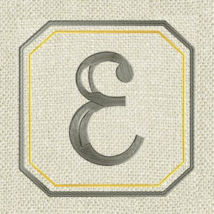 May include: A gray embroidered letter "E" in a gold and gray octagonal frame on a beige linen background.