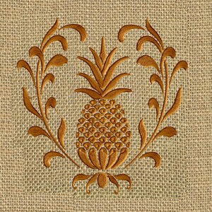 May include: Embroidered pineapple design on a burlap background. The pineapple is surrounded by stylized leaves in a heart shape.