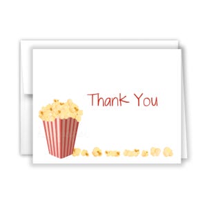 May include: A white thank you card with a red and white striped popcorn bucket filled with popcorn and the text "Thank You" in red.