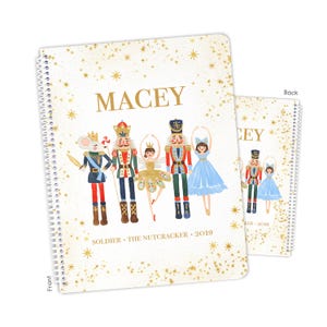 May include: A spiral-bound notebook with a white cover featuring gold star accents and the name MACEY in gold text. The illustration depicts a mouse soldier, a nutcracker, a fairy, and a ballerina. Text at the bottom reads SOLDIER • THE NUTCRACKER • 2019.