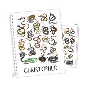 May include: A spiral-bound notebook featuring colorful illustrations of various snake species, including the Boa Constrictor and Eastern Massasauga Rattlesnake. The name "Christopher" is printed in large letters at the bottom of the front cover.