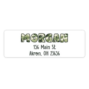 May include: A white rectangular label with a camouflage pattern name "MORGAN" in green and brown. The address is 156 Main St Akron, OH 23656.