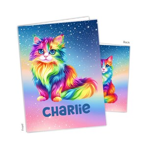 May include: A rectangular greeting card featuring a vibrant, multi-colored long-haired cat illustration against a starry, gradient background. The front displays the name CHARLIE in bold blue letters, while the back shows a partial view of the cat.