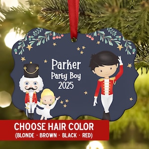May include: Navy blue Christmas ornament with a red ribbon. The ornament features a cartoon illustration of a nutcracker, a ballerina, and a party boy. Text on the ornament reads "Parker Party Boy 2025". The bottom of the ornament has text that reads "CHOOSE HAIR COLOR".