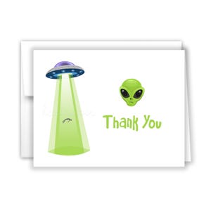 May include: A white thank you card with a green alien head and a cartoon spaceship with a green beam of light. The text "Thank You" is written in green letters.