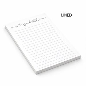 Puede incluir: Un bloc de notas rectangular blanco con l&iacute;neas horizontales negras y el nombre elizabeth impreso en una escritura cursiva negra en la parte superior. La palabra LINED est&aacute; impresa en letras may&uacute;sculas negras en la esquina superior derecha.