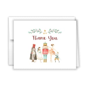 May include: A watercolor thank you card with a Nutcracker theme. The card features a Nutcracker, a ballerina, a mouse king, and a young girl. The card is decorated with a green garland and gold stars. The text "Thank You" is written in red.