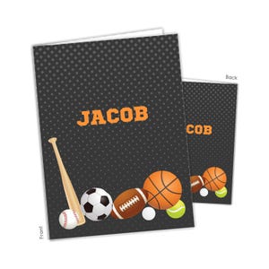May include: A personalized greeting card with a black background and a pattern of small gray dots. The card features the name "JACOB" in orange block letters and illustrations of various sports balls, including a baseball, soccer ball, football, and basketball.