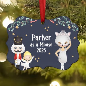May include: Navy blue ornament with a red ribbon, featuring a Nutcracker, a ballerina, and a mouse character. The text reads "Parker as a Mouse 2025" with star and floral accents. A festive holiday decoration.
