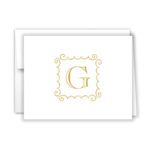 May include: A white card with a gold monogram of the letter "G" in a decorative frame.
