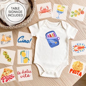 May include: A white short-sleeved baby bodysuit featuring a graphic of a blue sardine tin. The bodysuit is surrounded by square cards displaying illustrations of a crab, gelato, tomatoes, a scooter, olives, lemons, pizza, lobster, pasta, and text reading Ciao!, la dolce vita, and TABLE SIGNAGE INCLUDED.