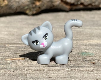 Chat gris, debout et regardant à gauche avec des yeux vert jaunâtre, un nez et une bouche rose foncé (Maxie) - Friends, Genuine LEGO® Animal