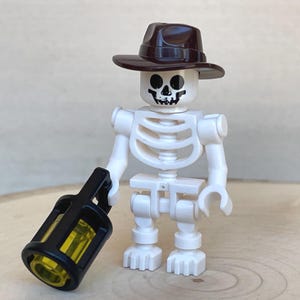 Skelett-Abenteurer mit einem dunkelbraunen Fedora-Hut und einer beleuchteten Laterne - Original LEGO® Minifigur