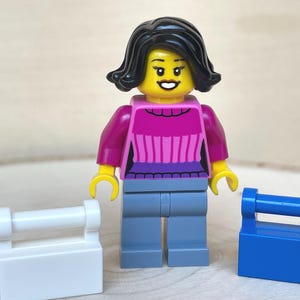 ダークピンクのセーターを着てショッピングバッグを持ったホリデーショッパーの女性 – 本物のレゴ®ミニフィギュア