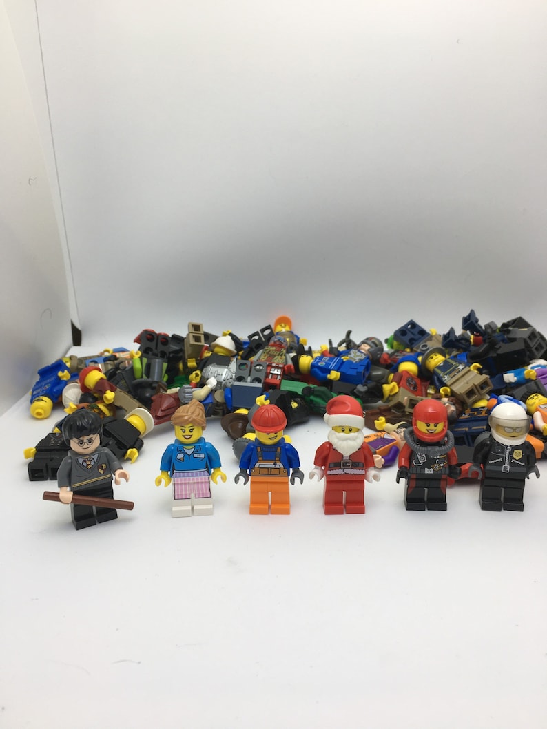 May include: A collection of assorted Lego minifigures, including a construction worker, a police officer, a Santa Claus, a woman with pink and blue clothing, a man with a black robe and glasses, and a man with a red helmet and black suit.