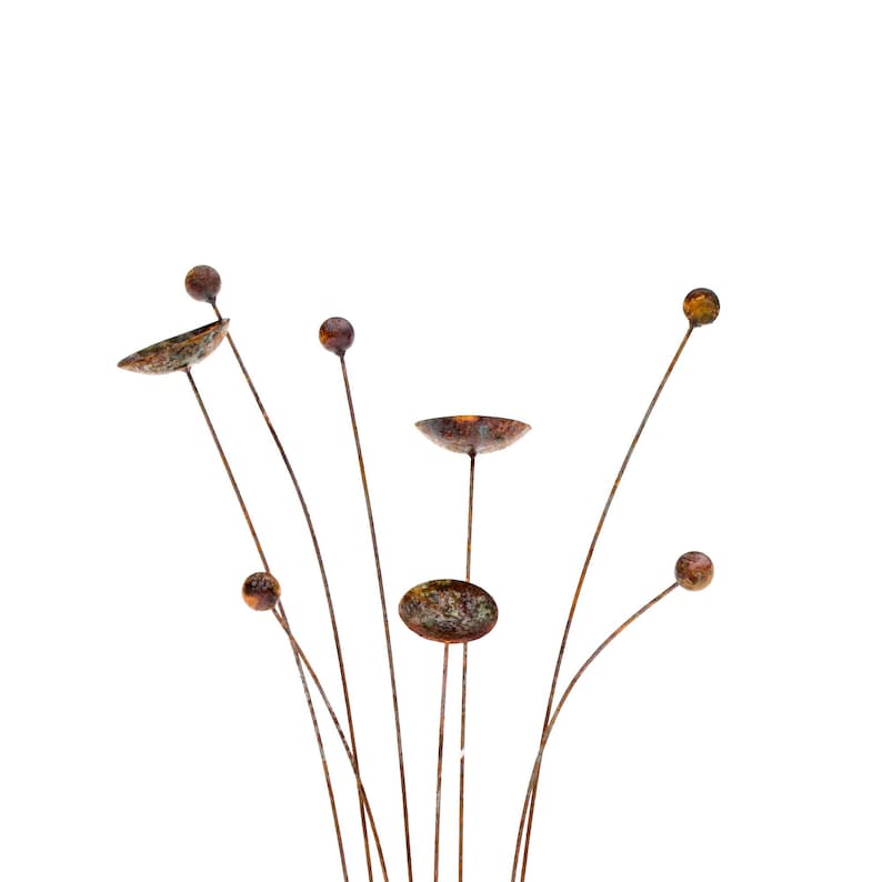 Kinetic metal garden art with rust patina.