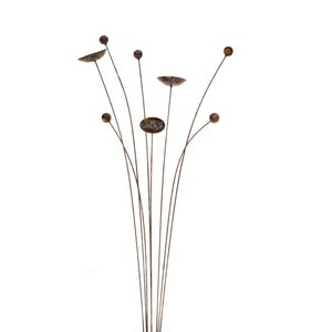 Metal kinetic garden art with rust patina