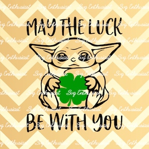 May include: A black and white illustration of a character from the Star Wars franchise holding a green four-leaf clover. The text "May the luck be with you" is written in black above the character.