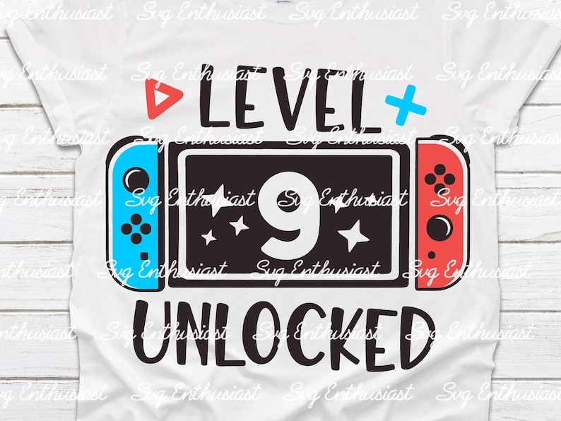 Puede incluir: Una camiseta blanca con un gr&aacute;fico en blanco y negro de una consola de videojuegos con el texto "LEVEL 9 UNLOCKED" en ella.