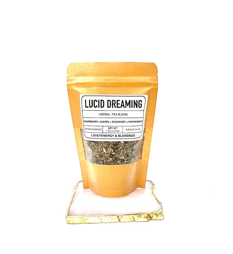 May include: A brown paper pouch with a white label that reads "LUCID DREAMING HERBAL TEA BLEND RASPBERRY LEAVES MUGWORT+PEPPERMAT DECAFFEINATED NET WT 1.30 oz (37g) BLENDED IN USA LOVEYENERGY & BLESSINGS". The pouch contains dried herbs.