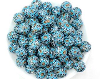 May include: A bowl of blue and brown patterned silicone beads. The beads are round and have a textured surface.