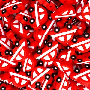 May include: A large group of red and white silicone beads shaped like fire trucks. The beads have black wheels and white details.