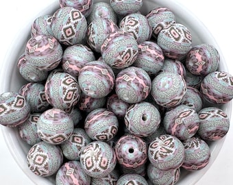 May include: A bowl of large, round, patterned beads in shades of gray, pink, and white. The beads have a geometric design and are made of silicone.