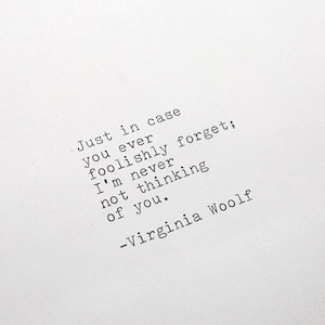 May include: A white piece of paper with a quote from Virginia Woolf printed on it. The quote reads: "Just in case you ever foolishly forget; I'm never not thinking of you." -Virginia Woolf