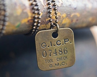 May include: A brass necklace with a square tag that reads "G.I.C.P. 07486 TOOL CHECK G.M.C."