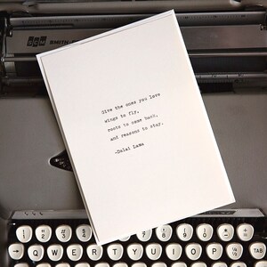 May include: A white card with a quote from the Dalai Lama typed on a vintage typewriter. The quote reads: "Give the ones you love wings to fly, roots to come back, and reasons to stay." -Dalai Lama