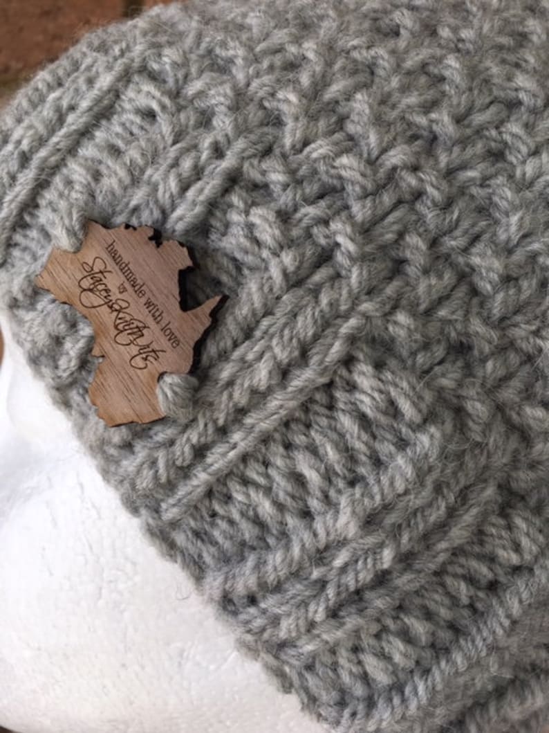 May include: Gray knitted beanie with a wooden tag that says "Handmade with love by Cozy Knit Co."