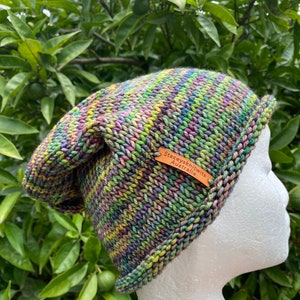May include: A colorful knitted beanie hat with a brown leather tag that reads "Stacey's Knits Australia".