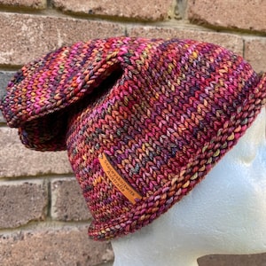 May include: A colorful knitted hat with a brown leather tag that says "Staceyknits Australia".