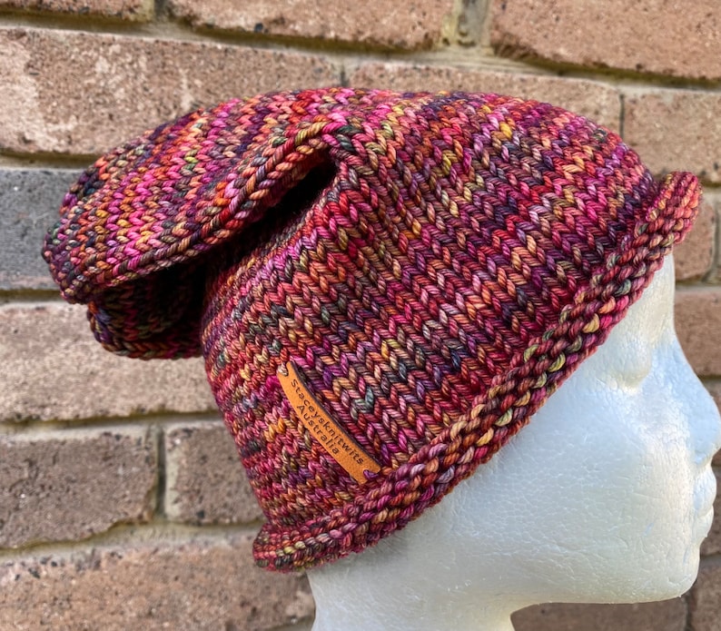 May include: A colorful knitted hat with a brown leather tag that says "Staceyknits Australia".