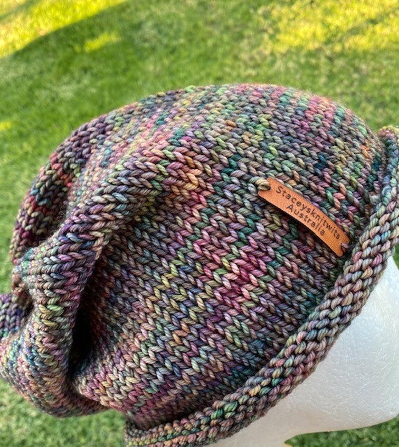 May include: A colorful knitted beanie hat with a brown leather tag that reads "Stacey's Knits Australia".